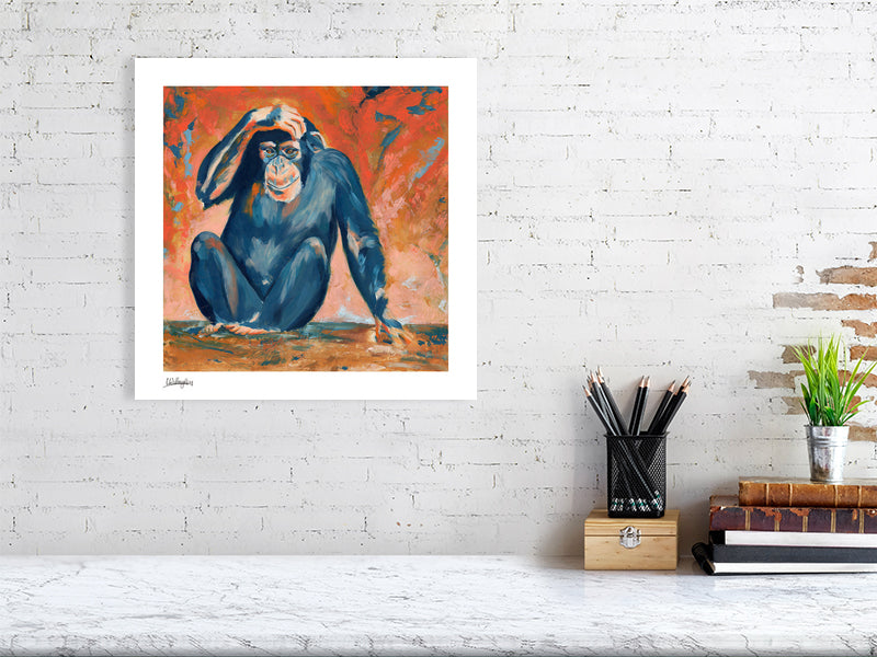 Wall art print of a chimpanzee on a white brick wall above a desk.