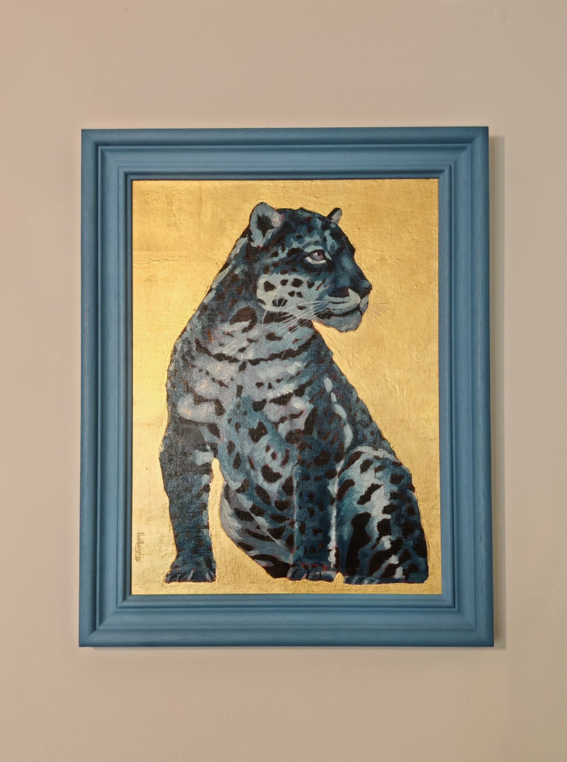 Framed artwork of a leopard on a gold background with a blue frame.